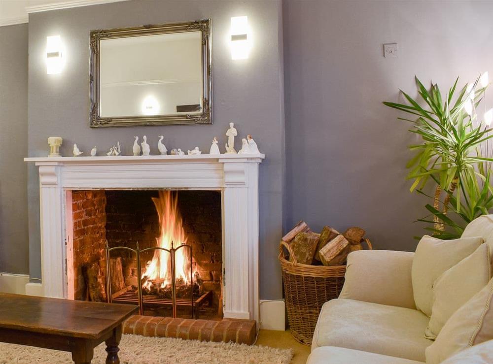 Warm and cosy living room with an open fire at Leygreen Farmhouse in Beaulieu, near Brockenhurst, Hampshire