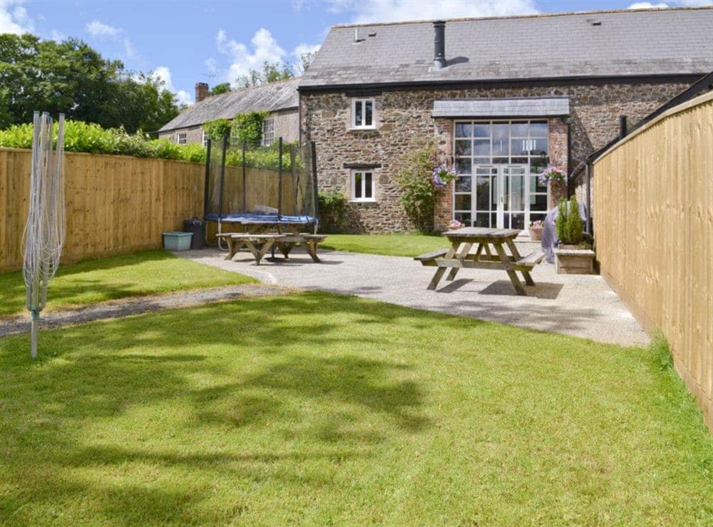 Enclosed garden with patio and outdoor furniture at Otters Den, 