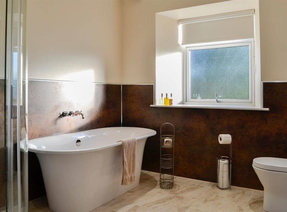 Bathroom with standalone bath and shower cubicle at Liftingstane Dairy Cottage, 