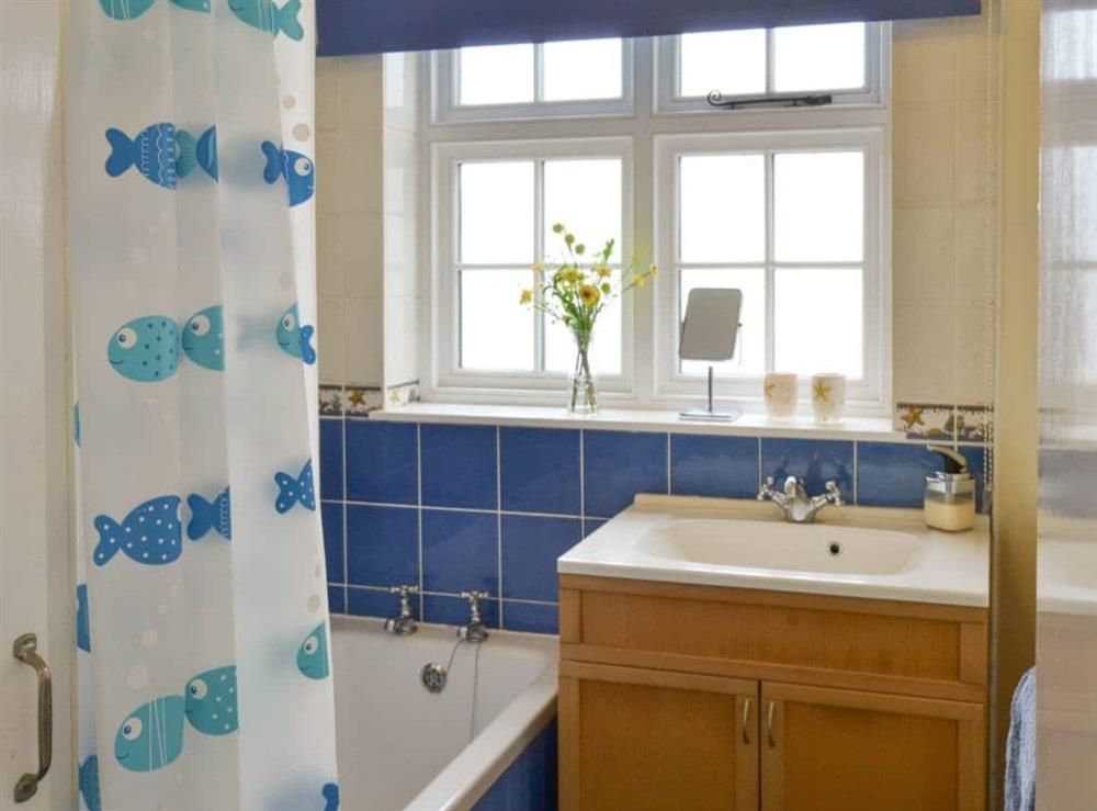 Family bathroom with shower over bath at Lighthouse Cottage in Happisburgh, Nr Cromer, Norfolk., Great Britain