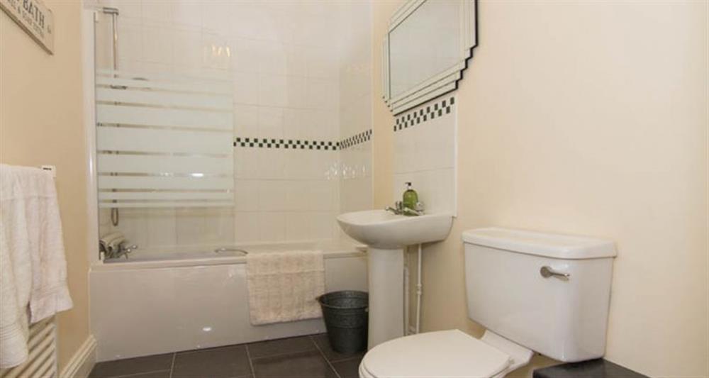 First floor:  Bathroom with bath with shower over at Lighthouse View, Cromer