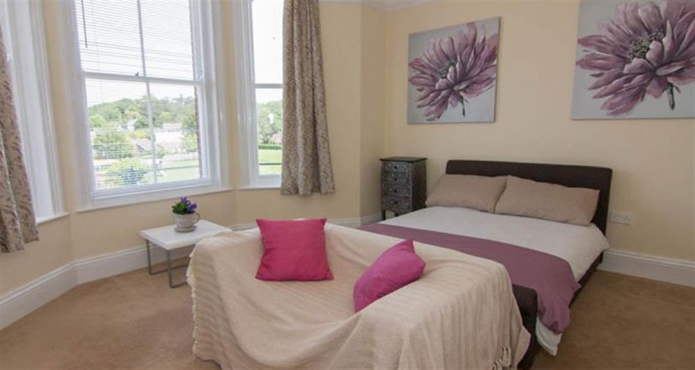 First floor:  Bedroom with double bed and small two-seater sofa at Lighthouse View, Cromer