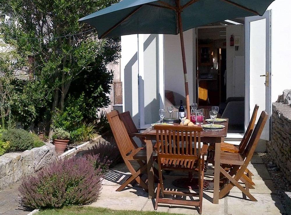 Attractive outdoor eating area of garden at Lime Cottage in Portland, near Weymouth, Dorset
