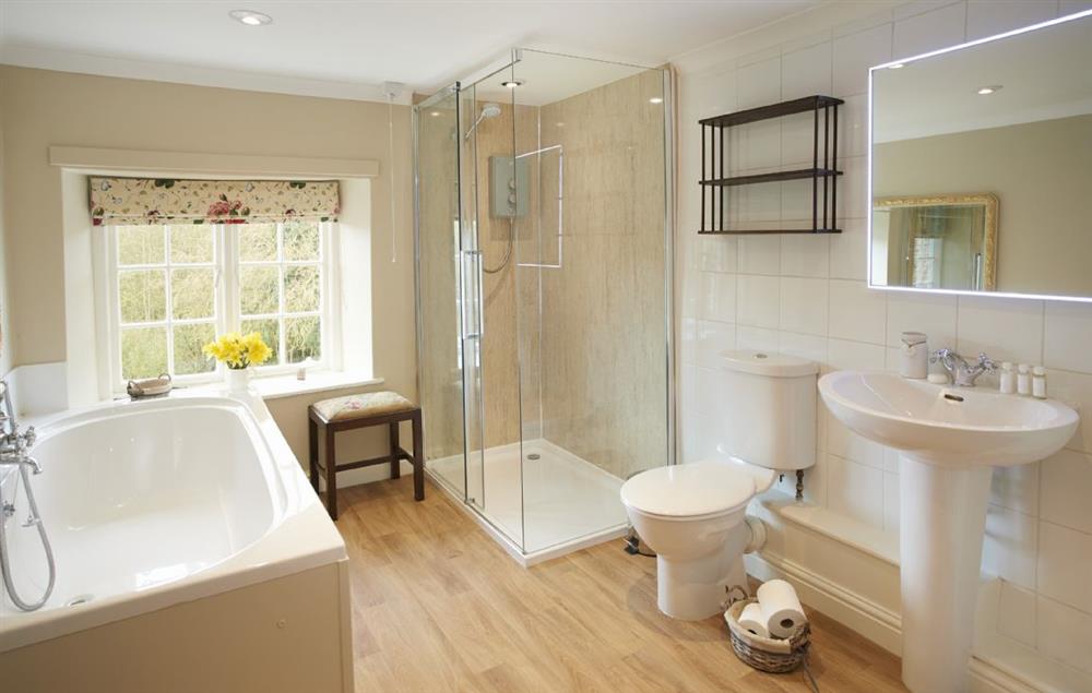 Family bathroom with large separate shower and bath with hand held shower attachment at Lime Kiln Farmhouse, Coneysthorpe