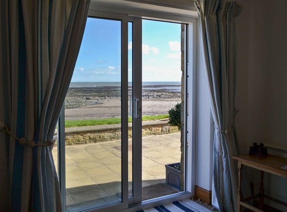 Patio doors in the living room allow the holidaymaker to enjoy the ever-changing sea views at Limpet Cottage in Boulmer, Northumberland