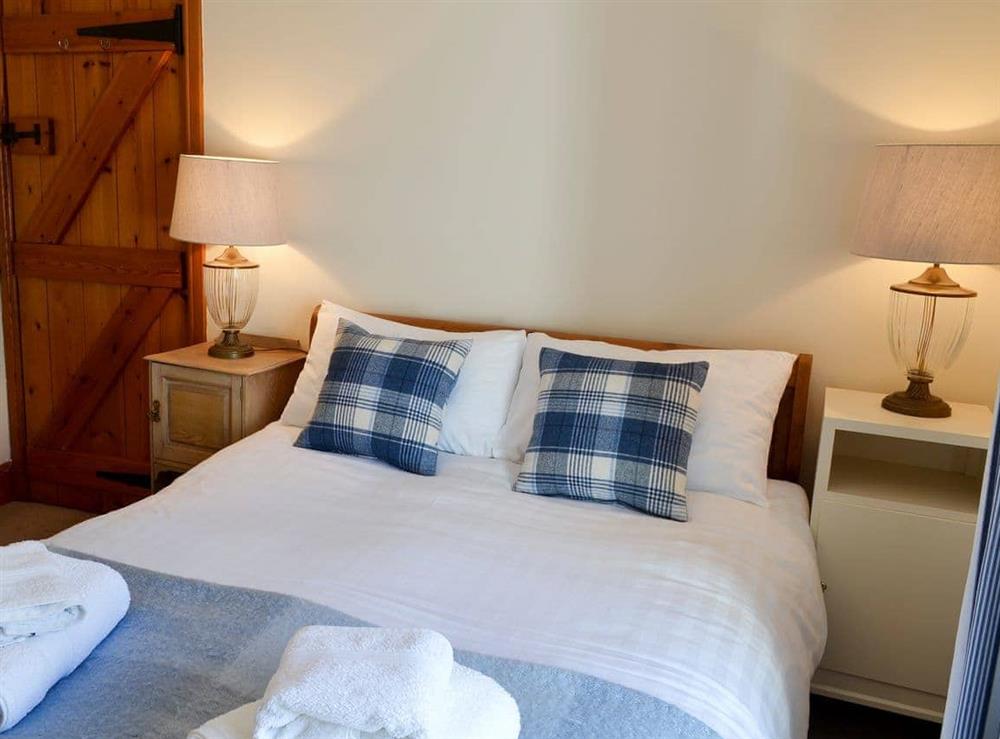The double bedroom has a comfortable bed with crisp white linen at Limpet Cottage in Boulmer, Northumberland