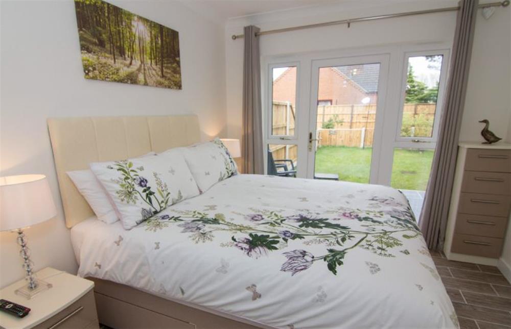 Ground floor:  King-size bedroom with glass door to enclosed rear garden at Little Birches, Roydon near Kings Lynn