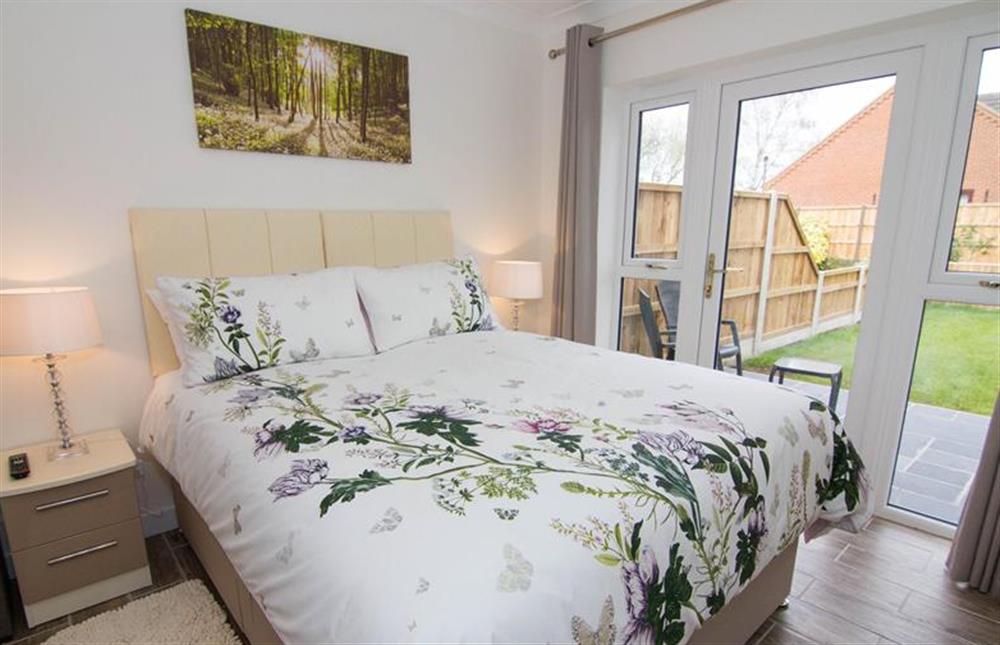 Ground floor:  King-size bedroom with wall mounted flatscreen televivion at Little Birches, Roydon near Kings Lynn