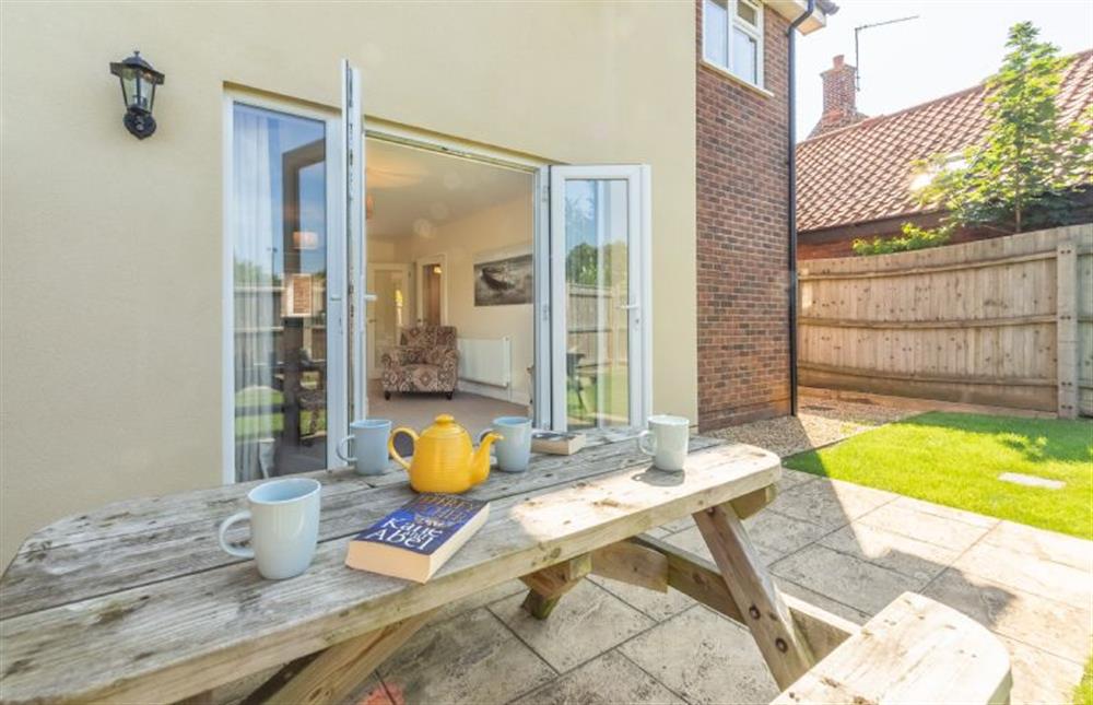Fully enclosed garden with patio area with table and seating for four at Little Bunting, Heacham near Kings Lynn
