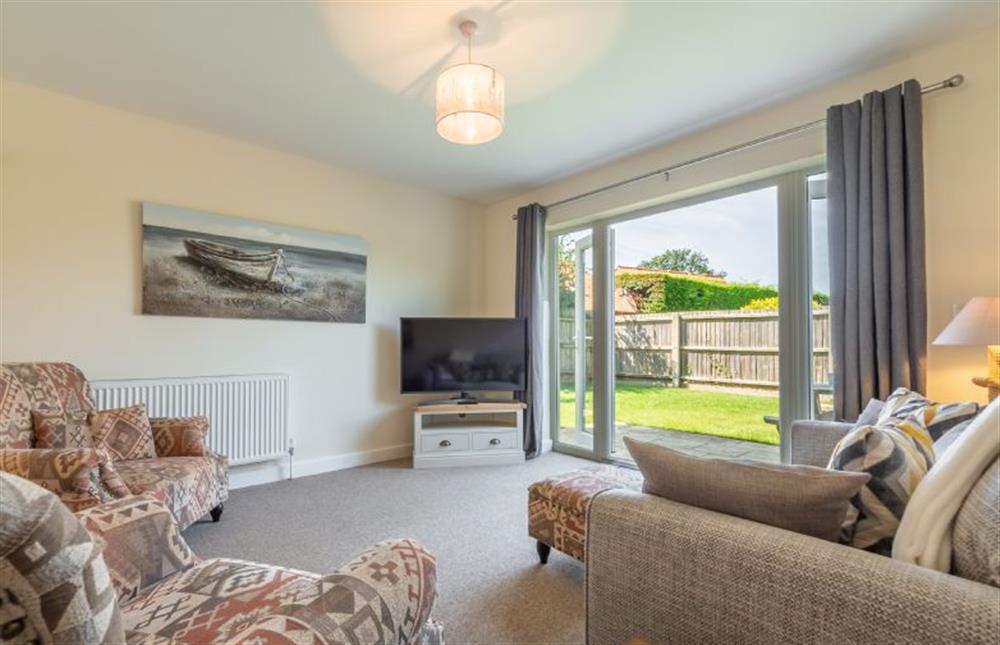 Ground floor:  Sitting area with comfy seating, flatscreen television and french doors to garden at Little Bunting, Heacham near Kings Lynn