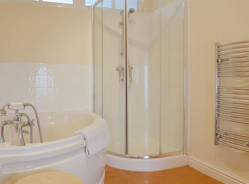 A corner bath with shower attachment is omplemented by a shower cubicle at Little Burcott Loft in Wells, Somerset