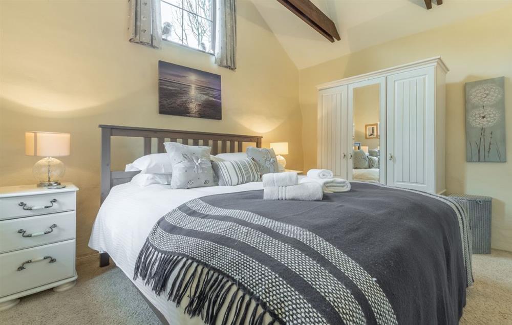 Bedroom one with king-size bed and en-suite bathroom at Little Gull, Roserrow