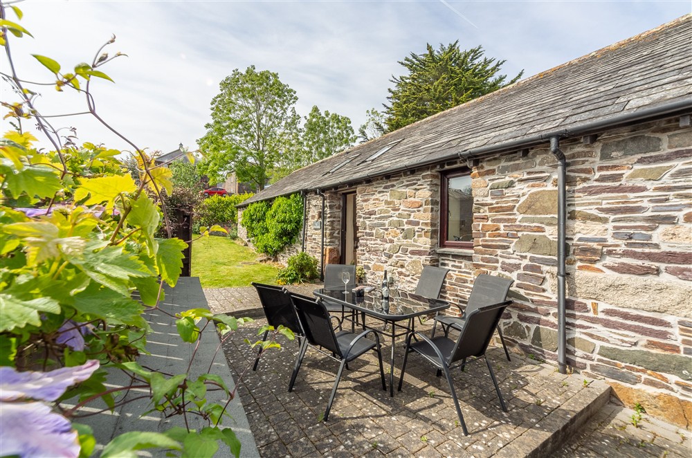 Little Gull, Roserrow. South-facing patio and lawned area with garden furniture at Little Gull, Roserrow