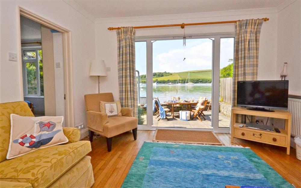 The sitting room with French windows onto the waterside terrace. at Little Haven in East Portlemouth