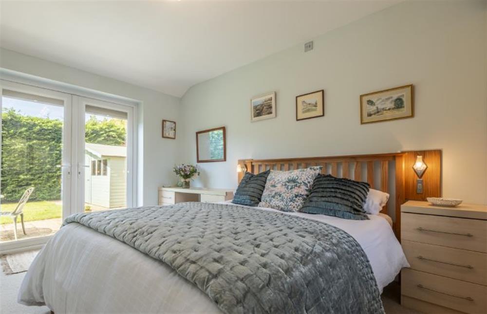 A lovely spacious bedroom that has doors to the garden at Little Hayman, Thornham near Hunstanton