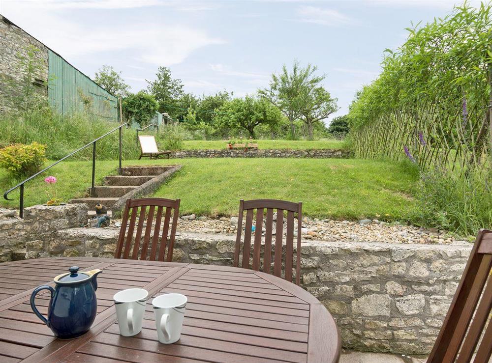 Lawned garden with patio and garden furniture at Little Orchard in High Littleton, near Bath, Avon