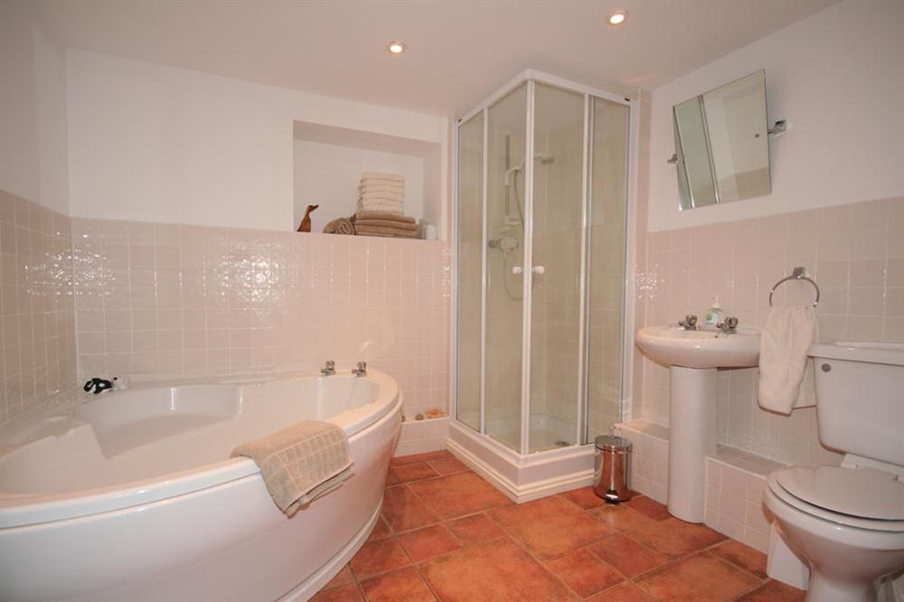 Bathroom with corner bath and shower at Little Perriotts in Kellaton, Nr Kingsbridge