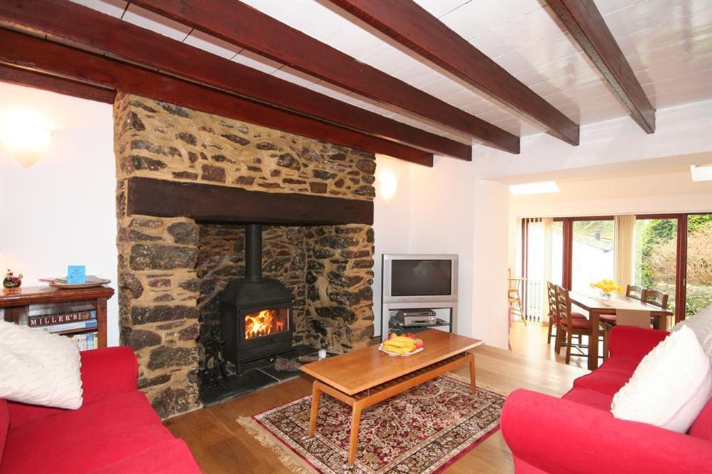 Lounge with stone fireplace and wood-burning stove at Little Perriotts in Kellaton, Nr Kingsbridge