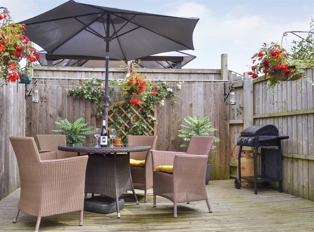 Enclosed patio area with outdoor furniture and BBQ