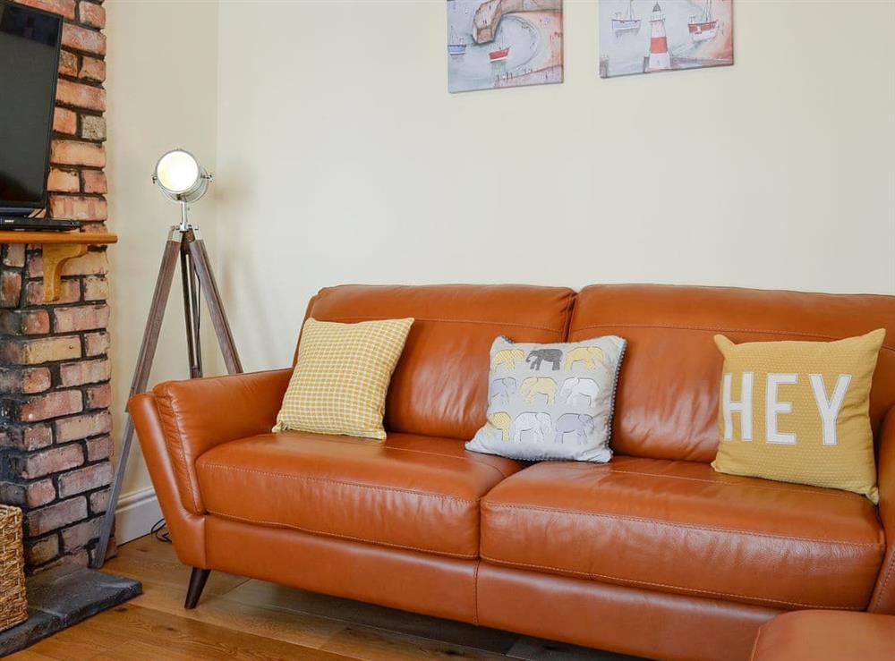 Living room with comfortable leather furniture at Llwynon Cottage in Llandudno, Conwy, Gwynedd