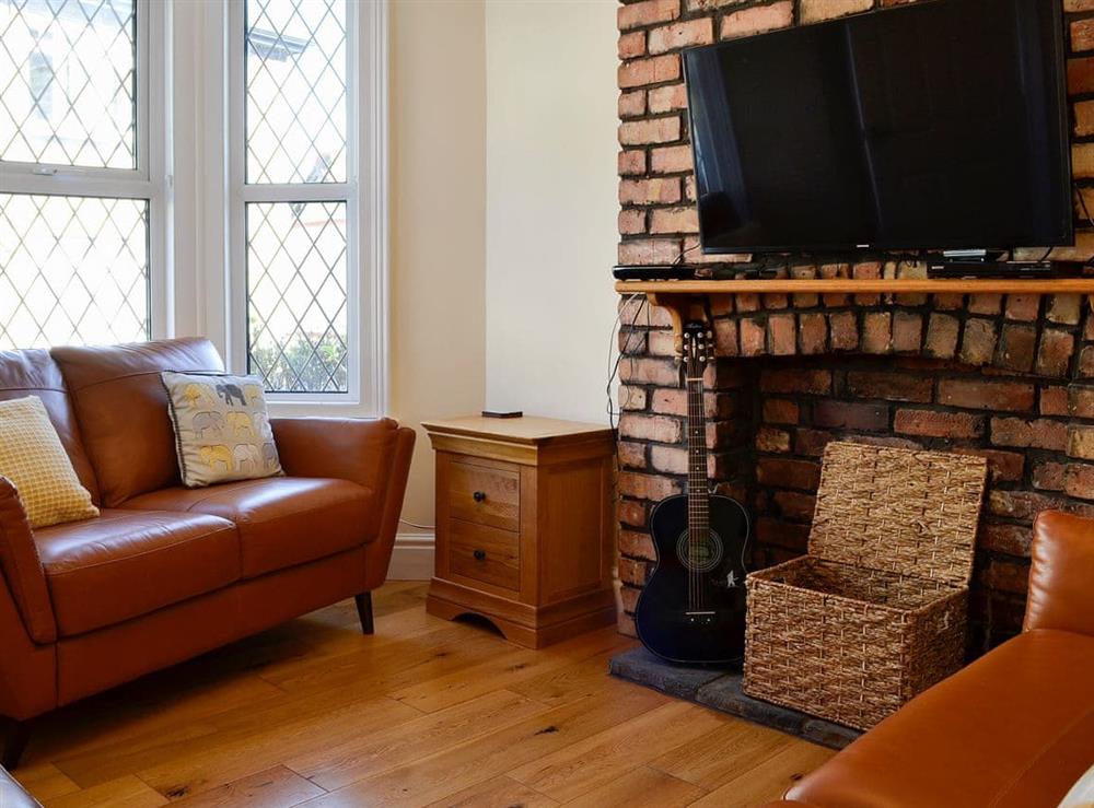 Wood-floored living room with feature fireplace at Llwynon Cottage in Llandudno, Conwy, Gwynedd