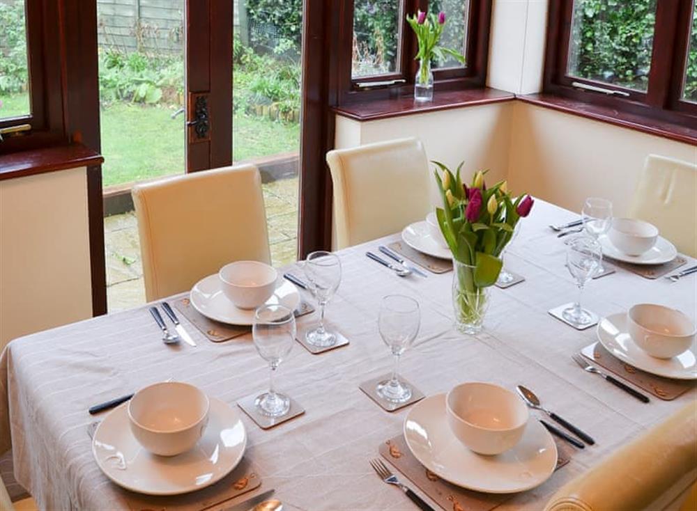 Delightful dining conservatory overlooking the garden at Lobelia Cottage in Stoke Holy Cross, near Norwich, Norfolk