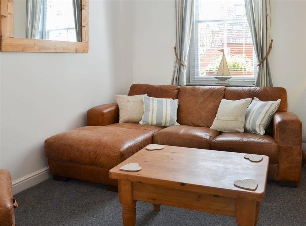 Cosy living room with leather furniture at Lobster Pot Cottage in Scarborough, North Yorkshire