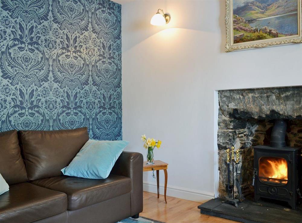 Homely living room with cosy multi-fuel burner at Loch Shore Cottage in Dornie, near Kyle, Ross-Shire