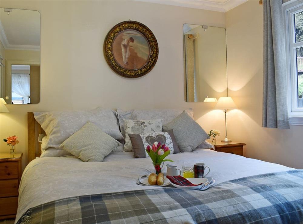 Attractively decorated double bedroom with kingsize bed at Loch View Cottage in Strathyre, near Callander, Perthshire