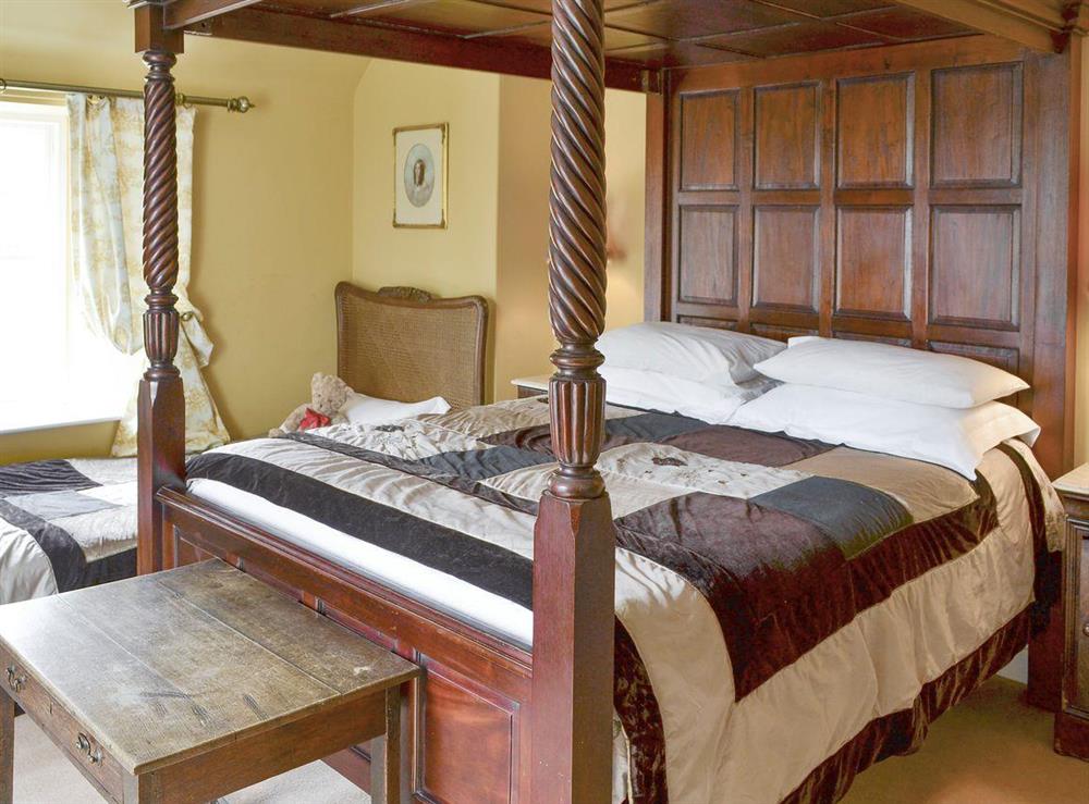 Family bedroom with a four poster and a single bed at Lochside Garden House in Kelso, Roxburghshire
