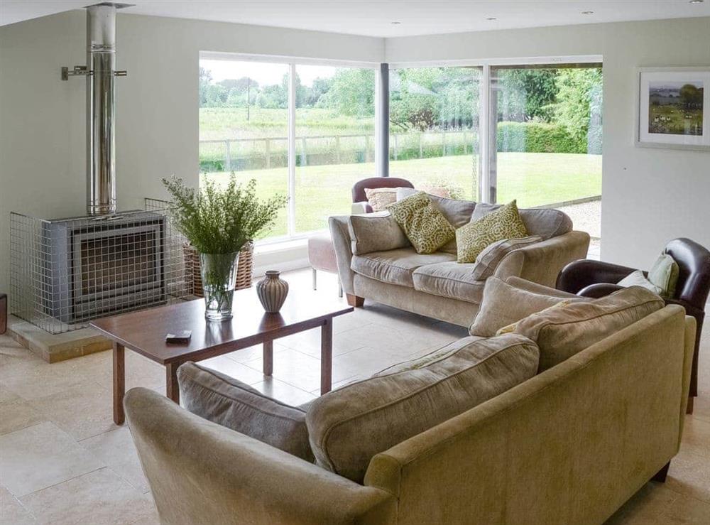 Stylish living area with picture windows overlooking garden at Lock Cottage in Aylsham, Norfolk., Great Britain