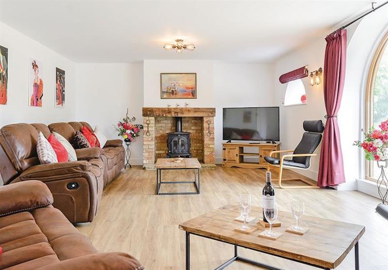 The Coach House living room and wood burner at Lode Hall Cottages in Three Holes, Cambridge