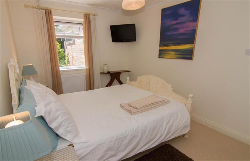Ground floor:  Bedroom one with king-size bed and television at Lodge End, Heacham near Kings Lynn
