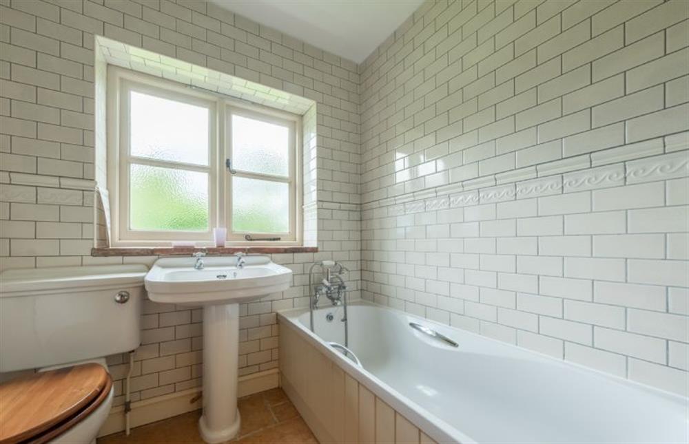 Ground floor: Family bathroom with a bath, WC and wash basin at Loke Cottage, Bessingham near Norwich