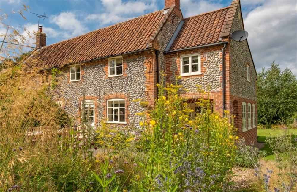 Loke Cottage: A brick and flint semi-detached cottage with front and rear gardens at Loke Cottage, Bessingham near Norwich