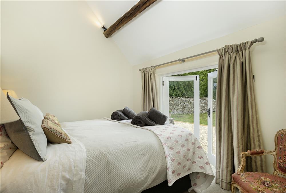 Ground floor: Master bedroom with 5ft king-size bed and french doors opening into the garden at Long Barn, near Cirencester