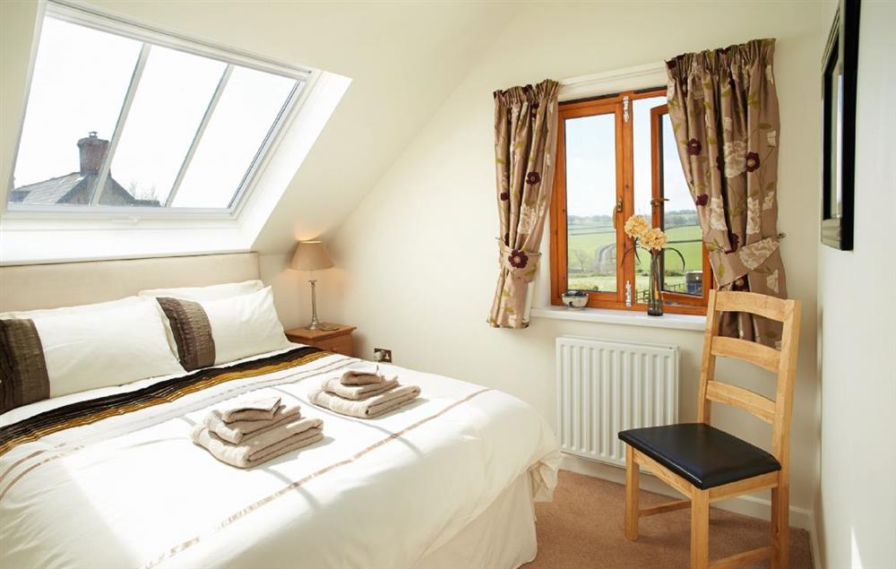 Master bedroom with 5’ bed and en-suite shower room at Long Meadow Barn, Down St Mary