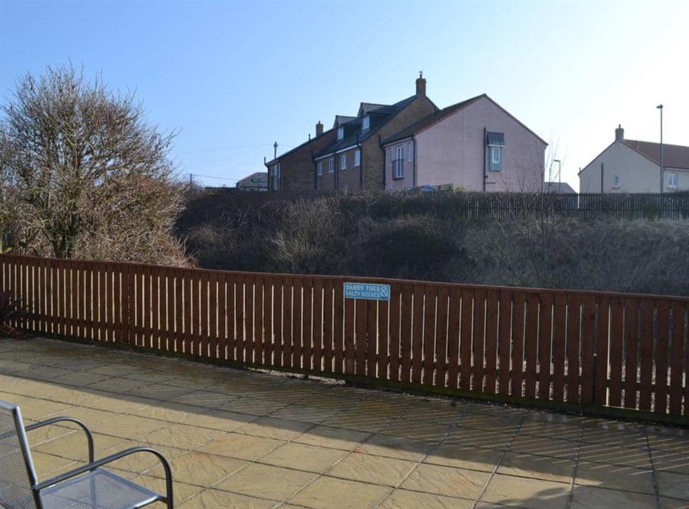 Enjoy the view of the lake and the wildlife from the patio at Longstone Bungalow in Beadnell, Northumberland
