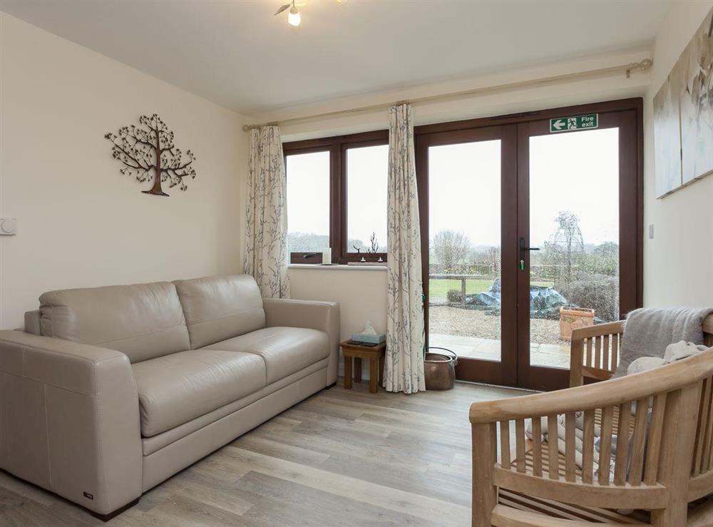 Seating area with patio doors to garden incorporates a sofa bed at Longview in Lower Stanton St. Quintin, near Chippenham, Wiltshire