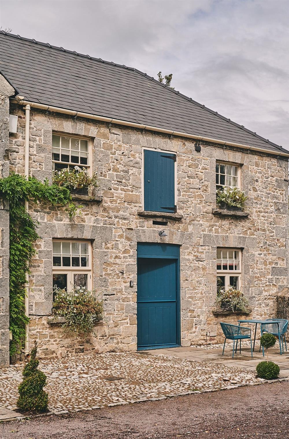 The exterior of the cottage with a table and chairs