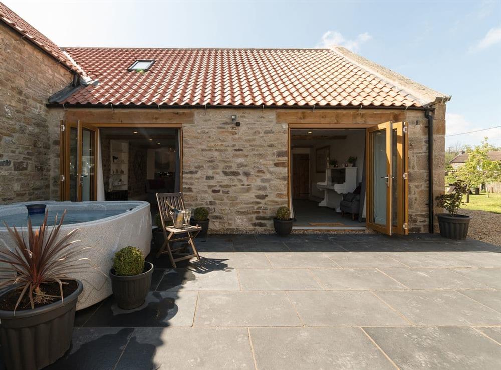 Paved courtyard with hot tub at Low Pasture Cottage in Hudswell, near Richmond, North Yorkshire