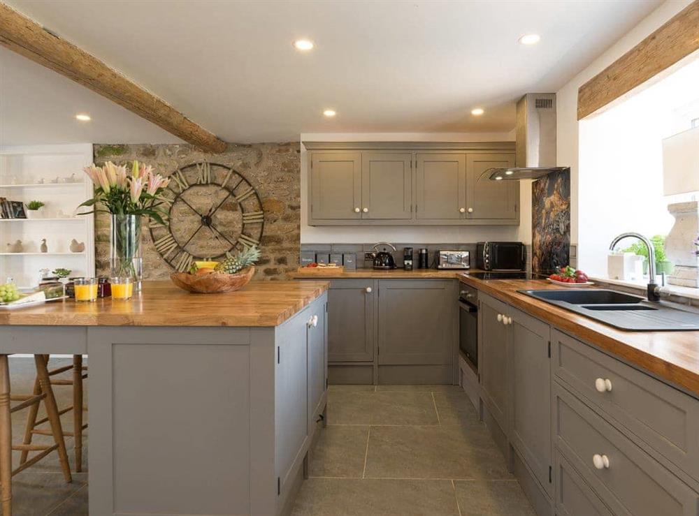 Well-equipped and fitted kitchen with breakfast island at Low Pasture Cottage in Hudswell, near Richmond, North Yorkshire