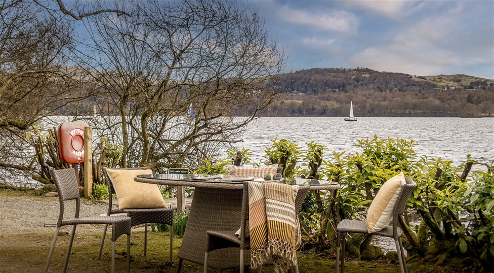The table and chairs by the jetty on Windermere at Low Strawberry Gardens in Nr Hawkshead, Cumbria