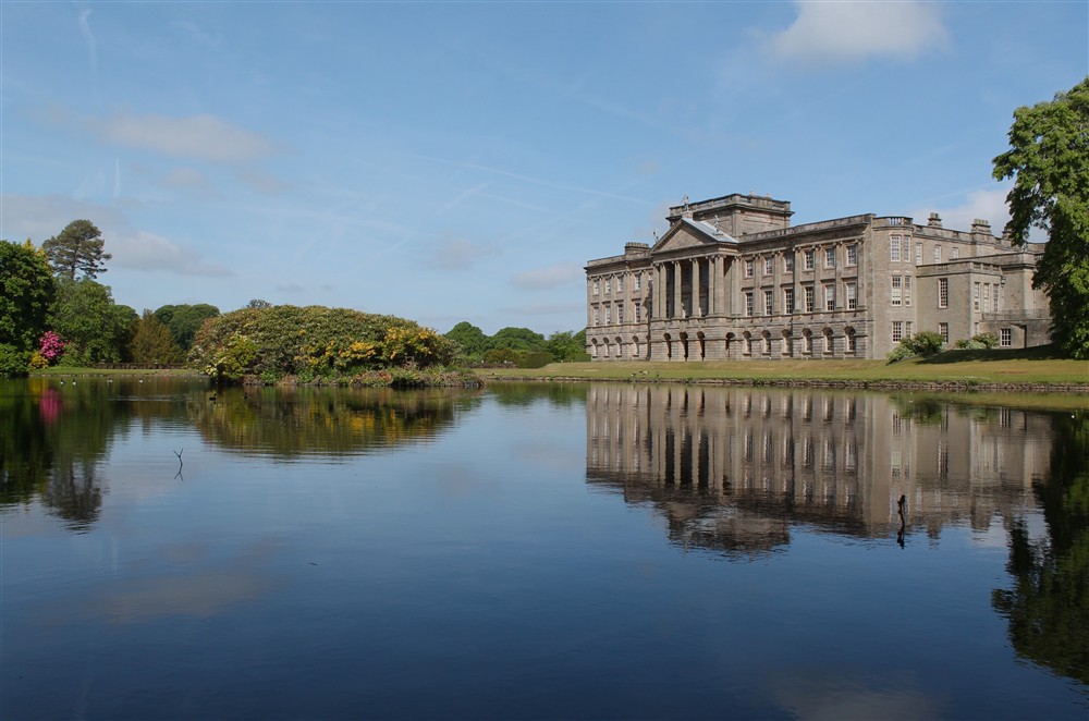 The South front of Lyme, Cheshire seen from across the reflecting lake on a sunny summers day. at Lyme West Lodge in Macclesfield, Cheshire