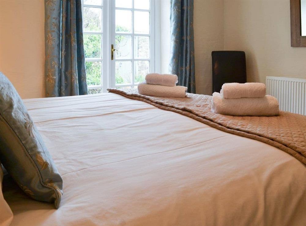 Double bedroom with French doors at Lynches in Parkham, near Bideford, Devon