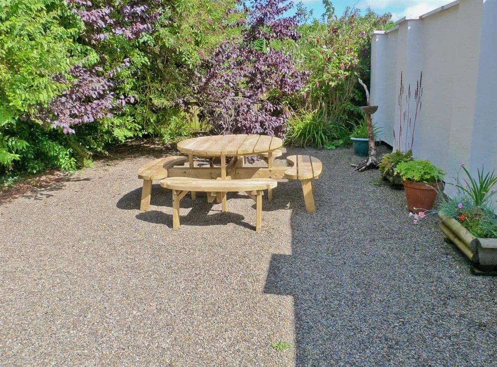 Picnic style seating in the gravelled courtyard at Lynches in Parkham, near Bideford, Devon