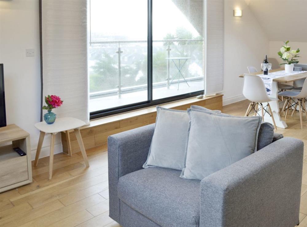 Open-plan living area with patio door to balcony at Lyndhurst in Perranporth, Cornwall