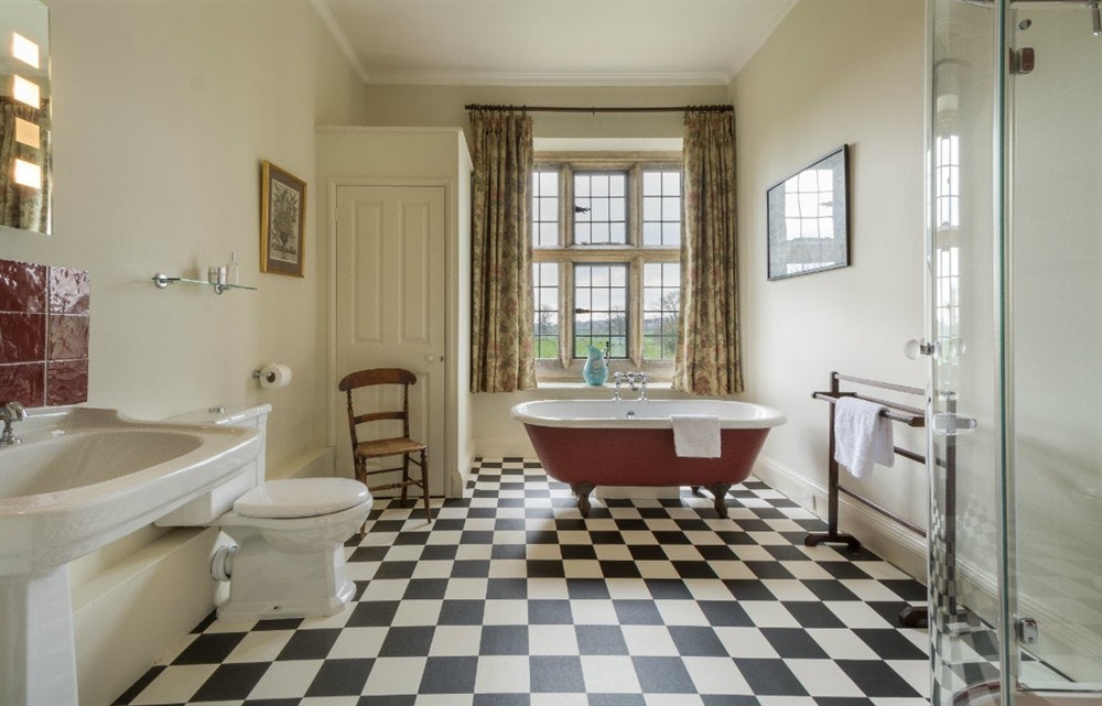 First-floor bathroom with roll-top bath and freestanding shower at Lytes Cary in Somerton, Somerset