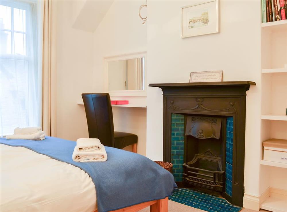 Bedrom with a feature open fireplace at Lythdene in Grange-over-Sands, Cumbria
