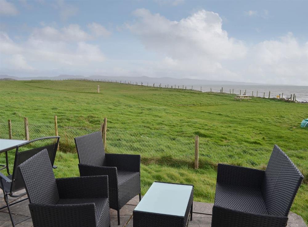 Delightful sitting out area with table and chairs at Maes y Mor in Criccieth, near Porthmadog, Gwynedd